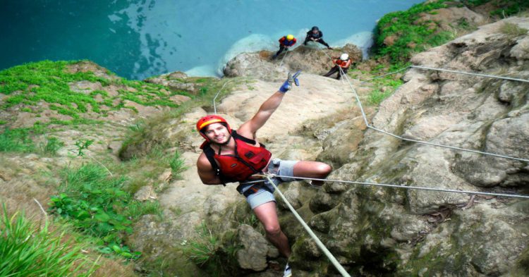 Persona practicando rappel en una cascada