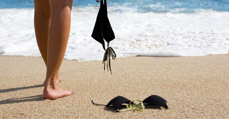 Mujer sin ropa en la playa.