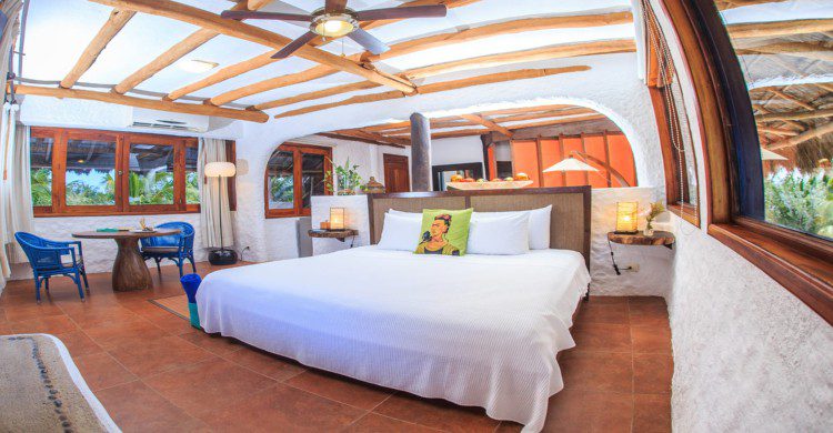 Habitación de lujo del hotel Las Nubes de Holbox con sabanas blancas y almohada de Frida Khalo