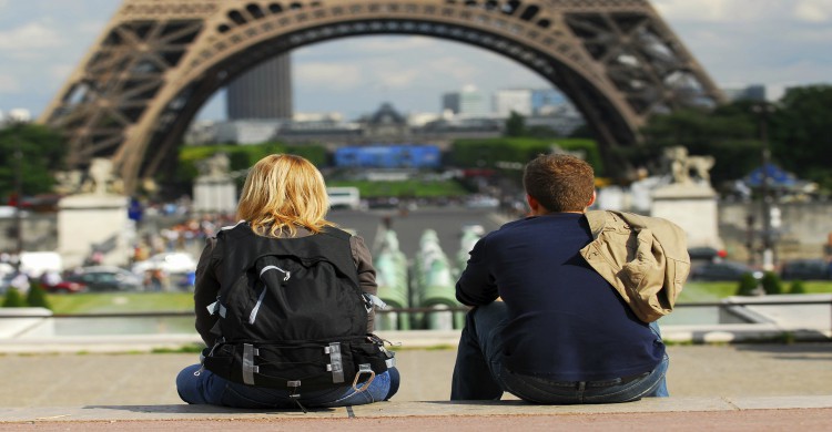 turistas visitando París Francia sentados frente a la Torre Eiffel de día