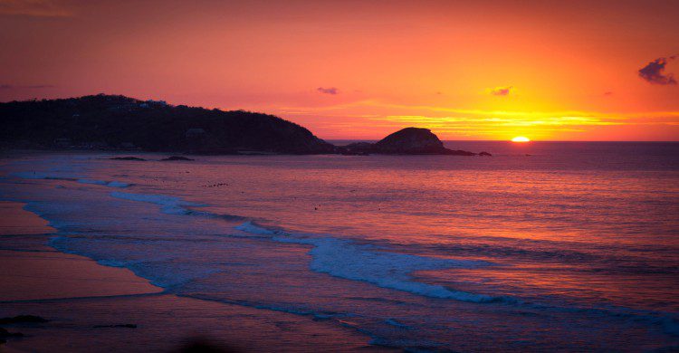 Zipolite al atardecer con la puerta de sol y cielo anaranjado
