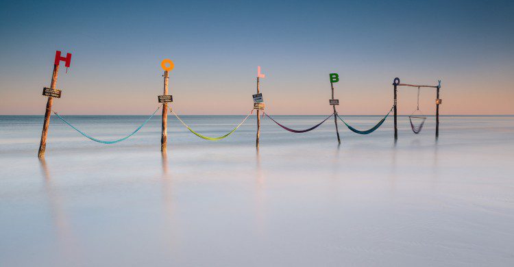 Letrero de Holbox a la orilla del mar cristalino