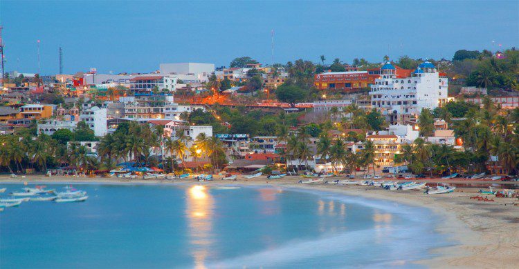 Mar de día con casas de fondo en Puerto Escondido