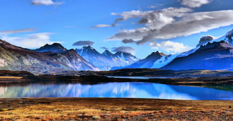 Montañas cubiertas de nieve, cielo azul y lago en Patagonia, Argentina