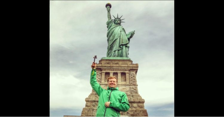 Hombre imitando la pose de la Estatua de la Libertad en Estados Unidos