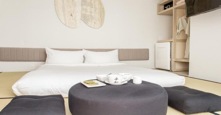 Cama de habitación con sillones negros en el hotel Ryo Kan
