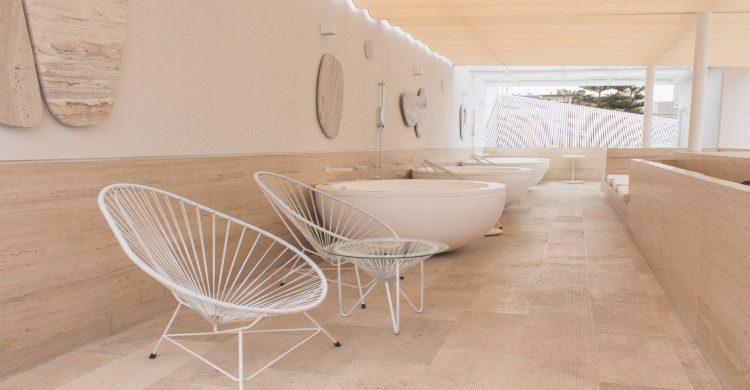 Tinas blancas sobre piso de madera con iluminación blanca en hotel Ryo Kan