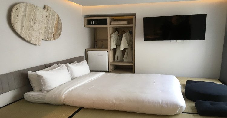 Cama con sábanas y almohadas blancas en el hotel Ryo Kan