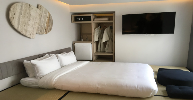 Cama con sábanas y almohadas blancas en el hotel Ryo Kan