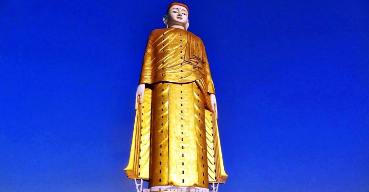 Estatua de Buda dorada con cielo azul de fondo